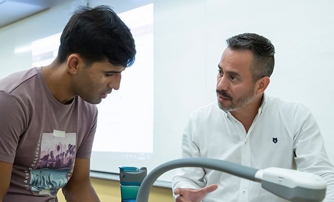 ESL teacher, Jhon Cardona, working with student in classroom