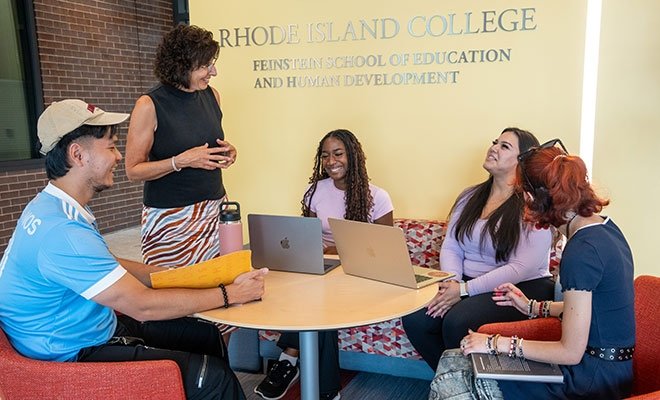 Carol Cummings talking with students in the lobby of Horace Mann