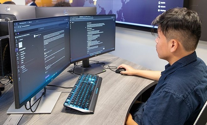 Student working at dual computer monitors in Cyber Range