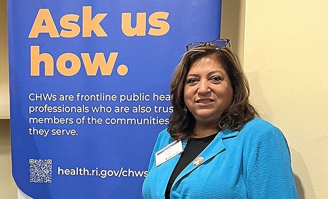 Woman standing in front of an "Ask us how" sign. 